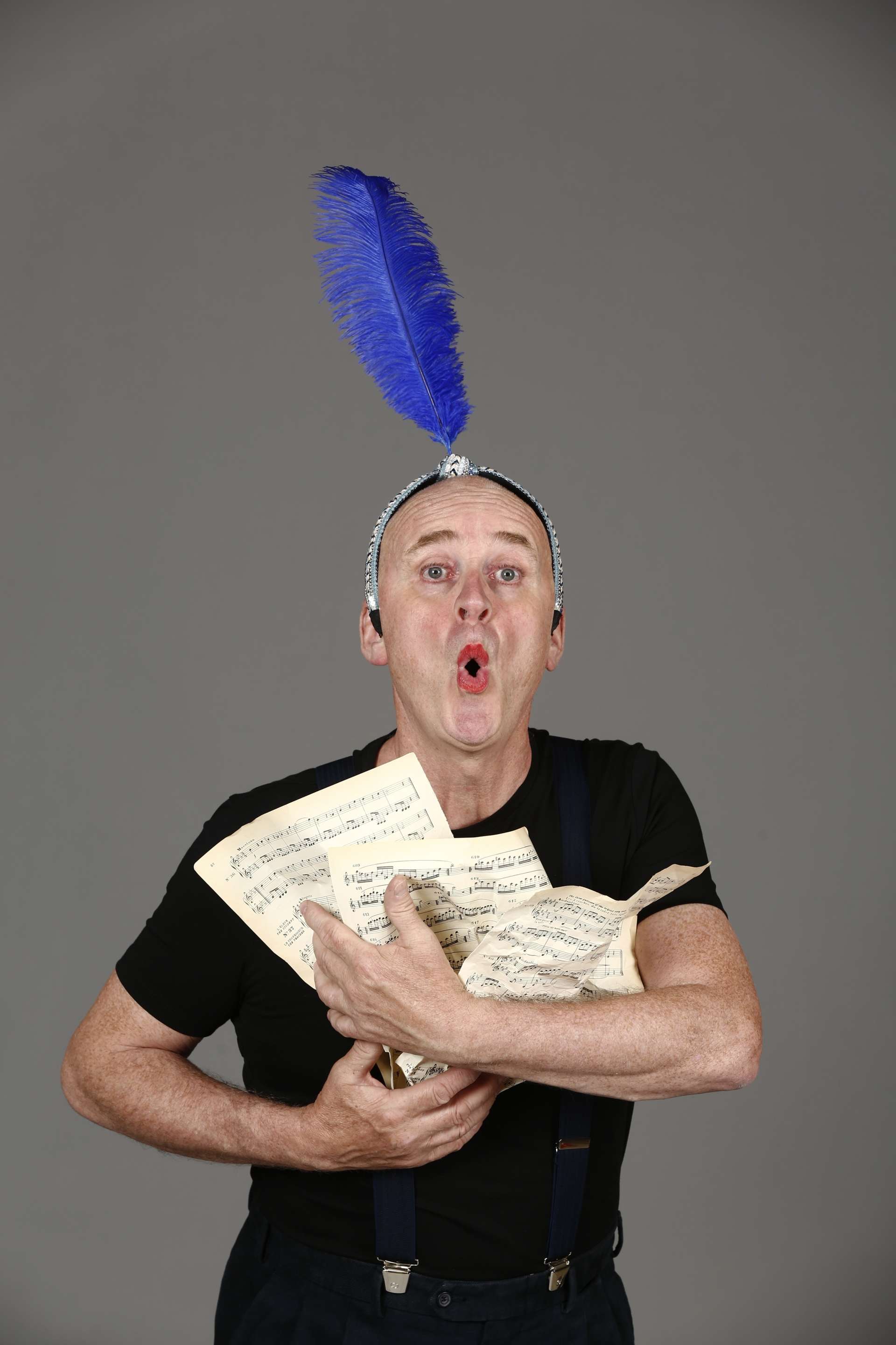 Damien Bouvet transformé en oiseau bleu qui chante et siffle avec des partitions plein les mains.