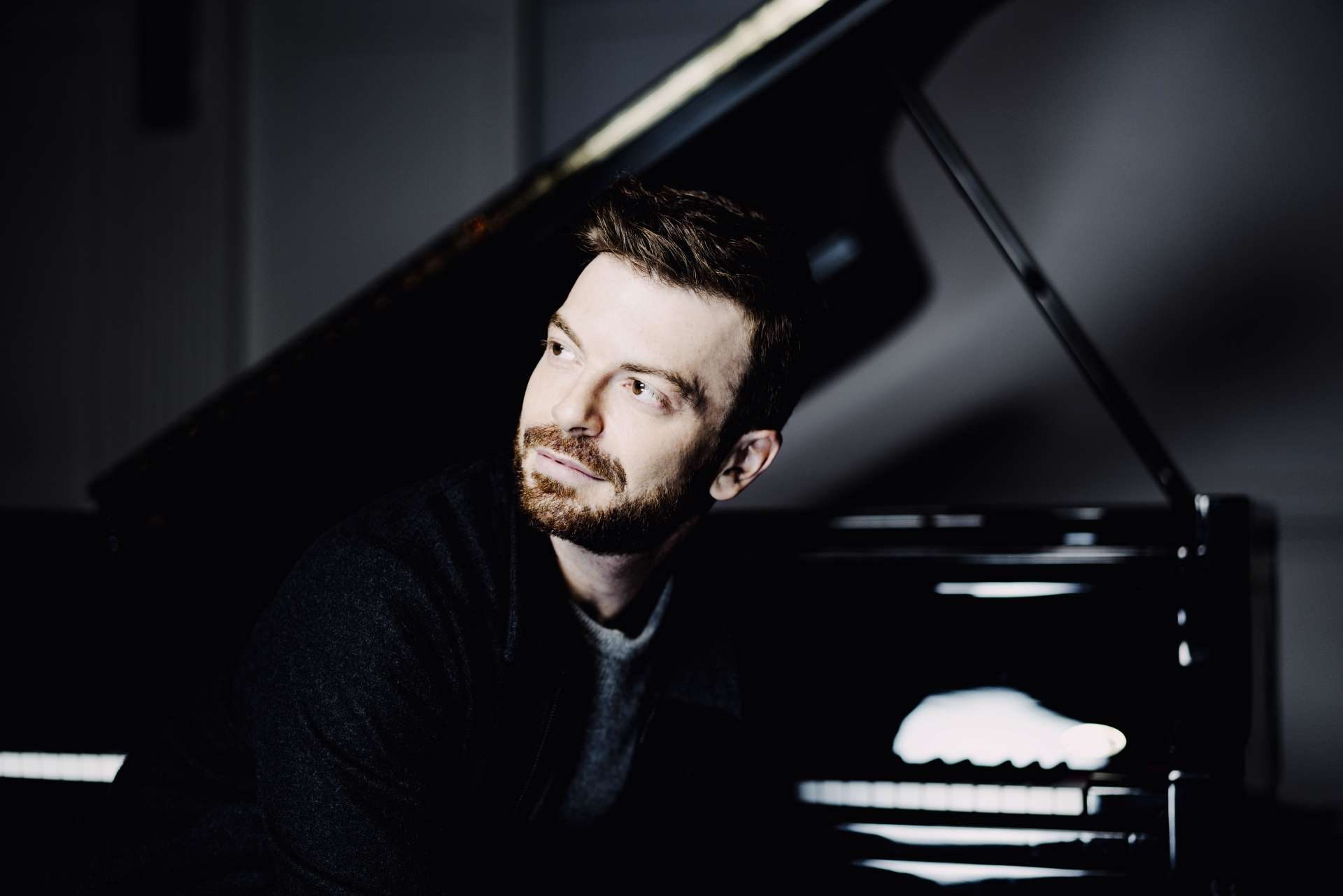 Portrait de David Kadouch devant son piano. 
