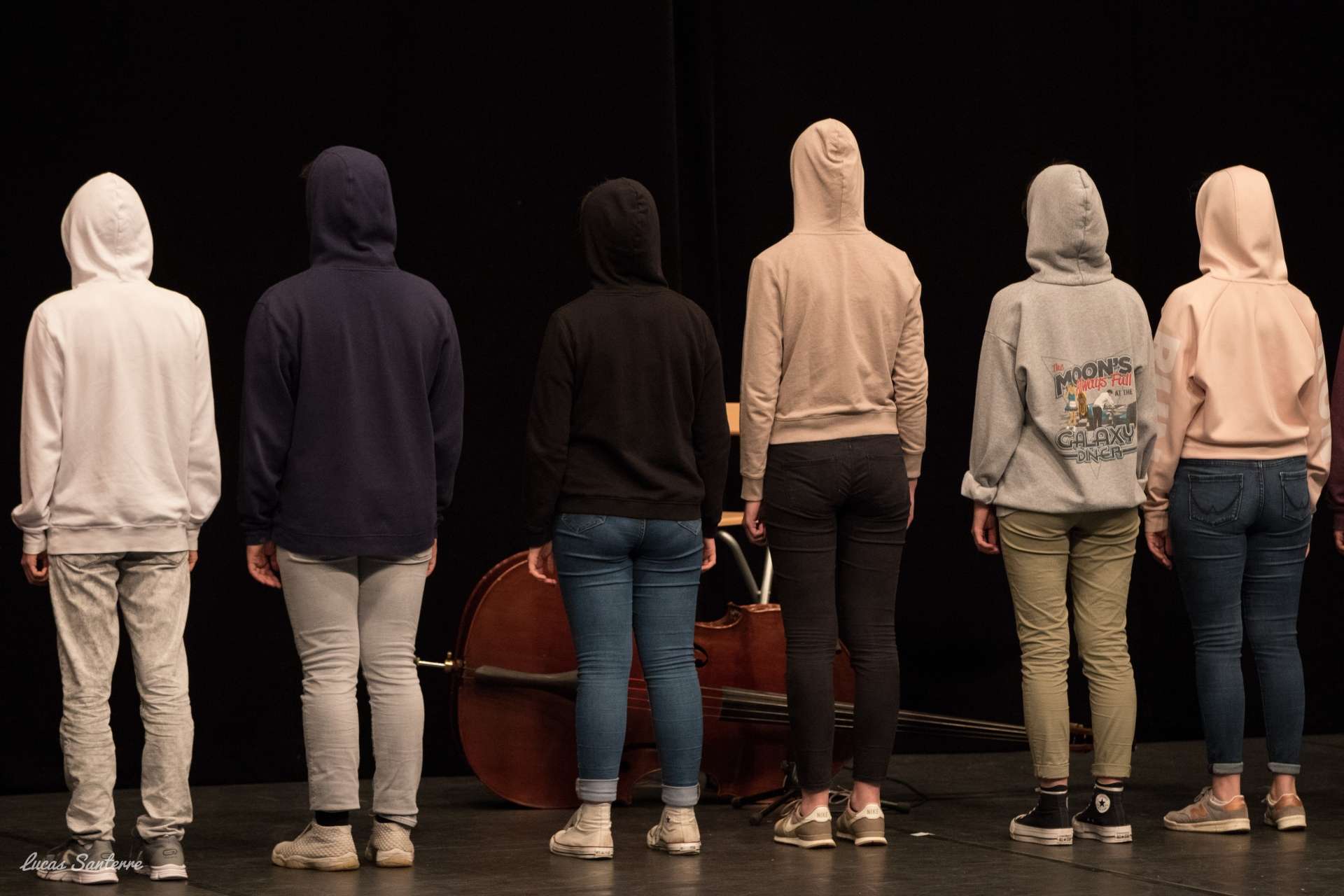 De dos sur scène, quelques jeunes avec des sweats à capuche