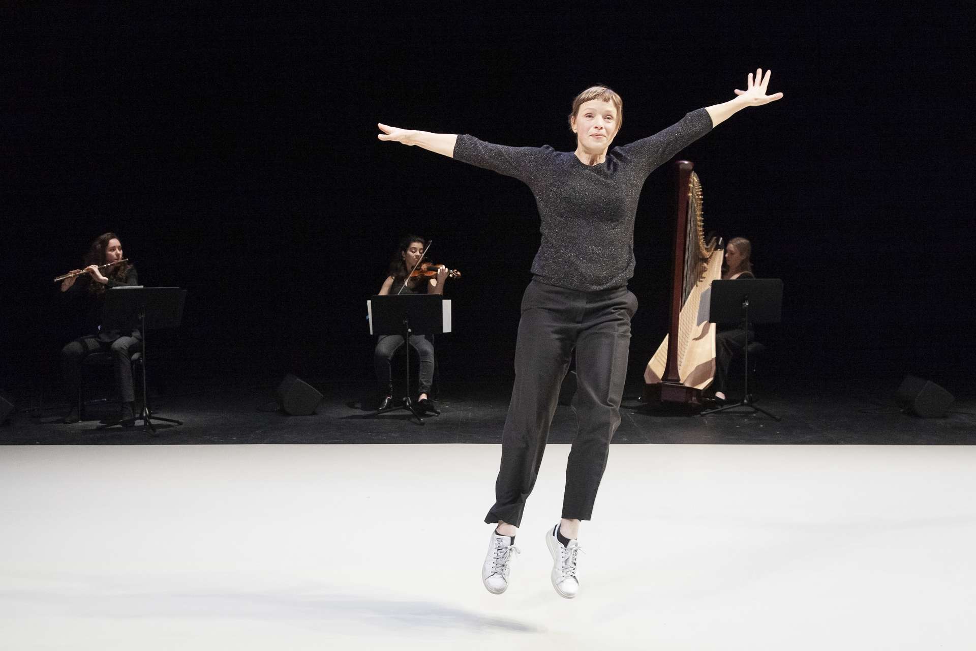 Samantha van Wissen, danseuse et interprète de Giselle..., effectue un saut en bord de scène alors que trois musiciennes jouent en fond de scène. 