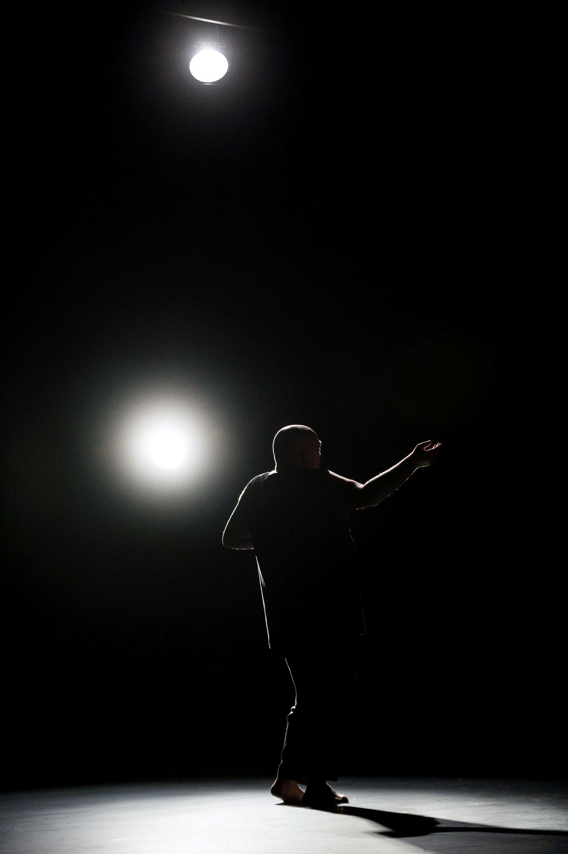 Dans la pénombre de la scène, la silhouette de Thomas Lebrun danse.