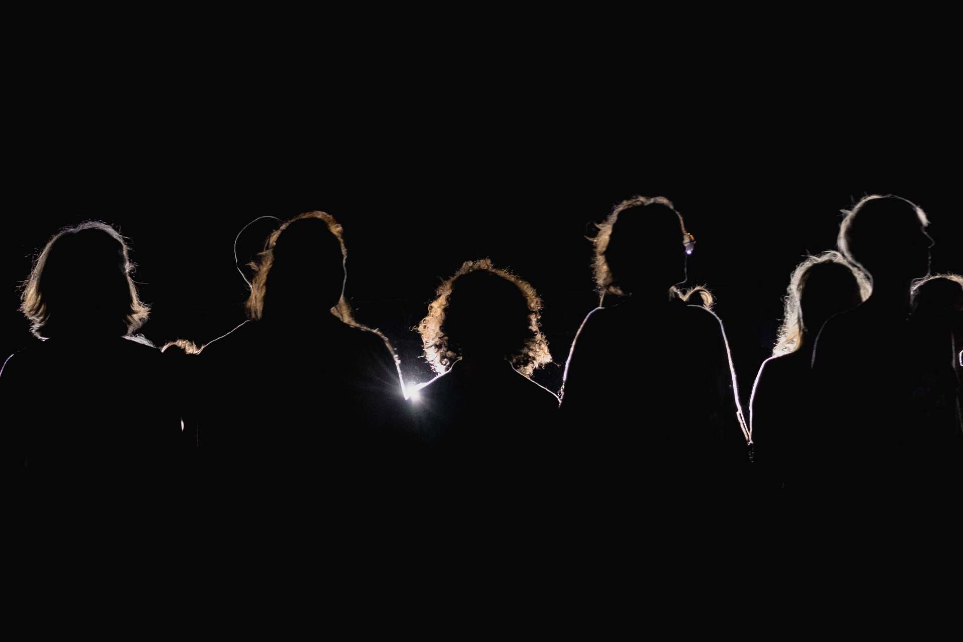 Quelques silhouettes surgissent de la pénombre. 