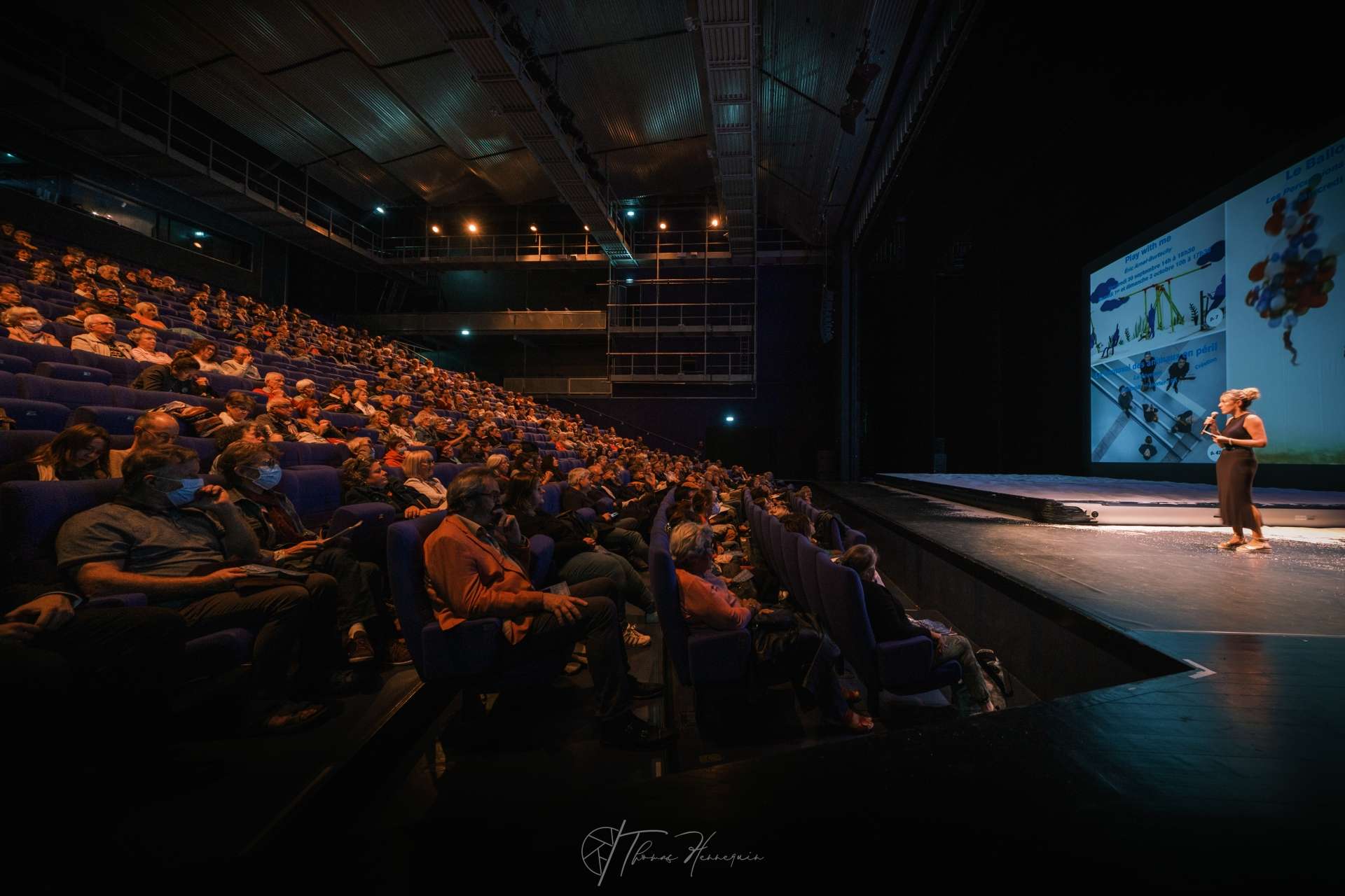 Sur scène, Elise Lory, chargée des relations avec le public. Micro à la main, elle s'adresse au public présent en salle Barrault afin de présenter la saison. 