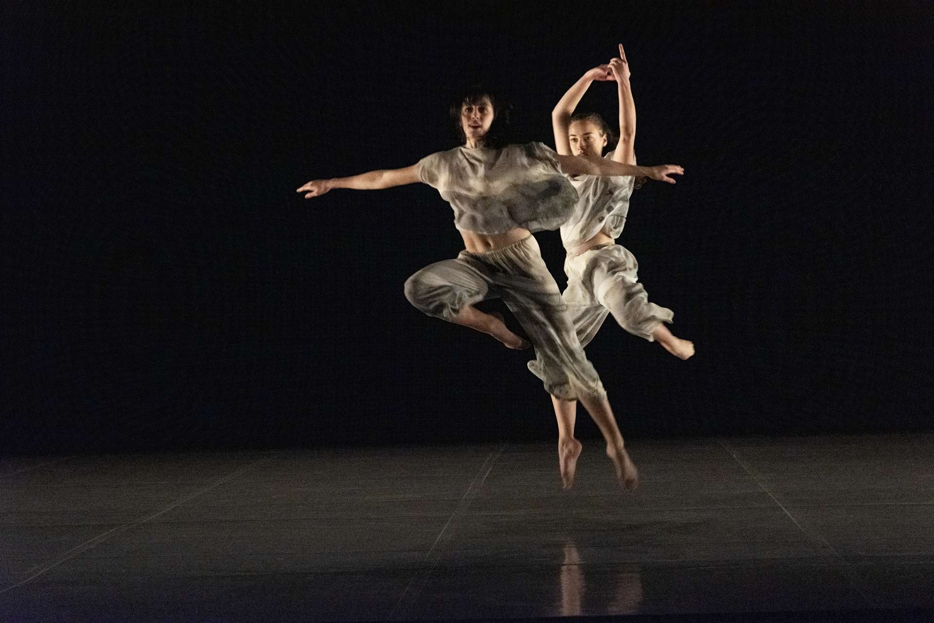 Deux interprètes sont en plein saut. 