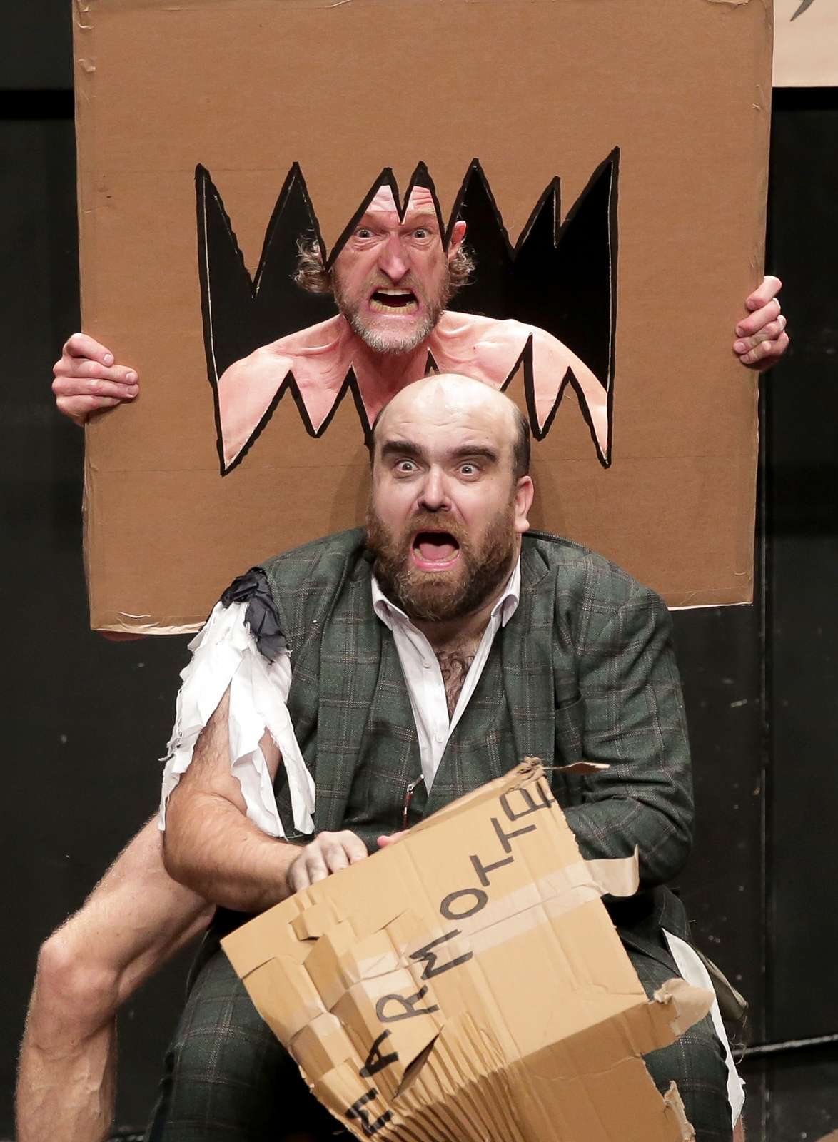Deux personnages dans un décor en carton et jouent avec des éléments en carton