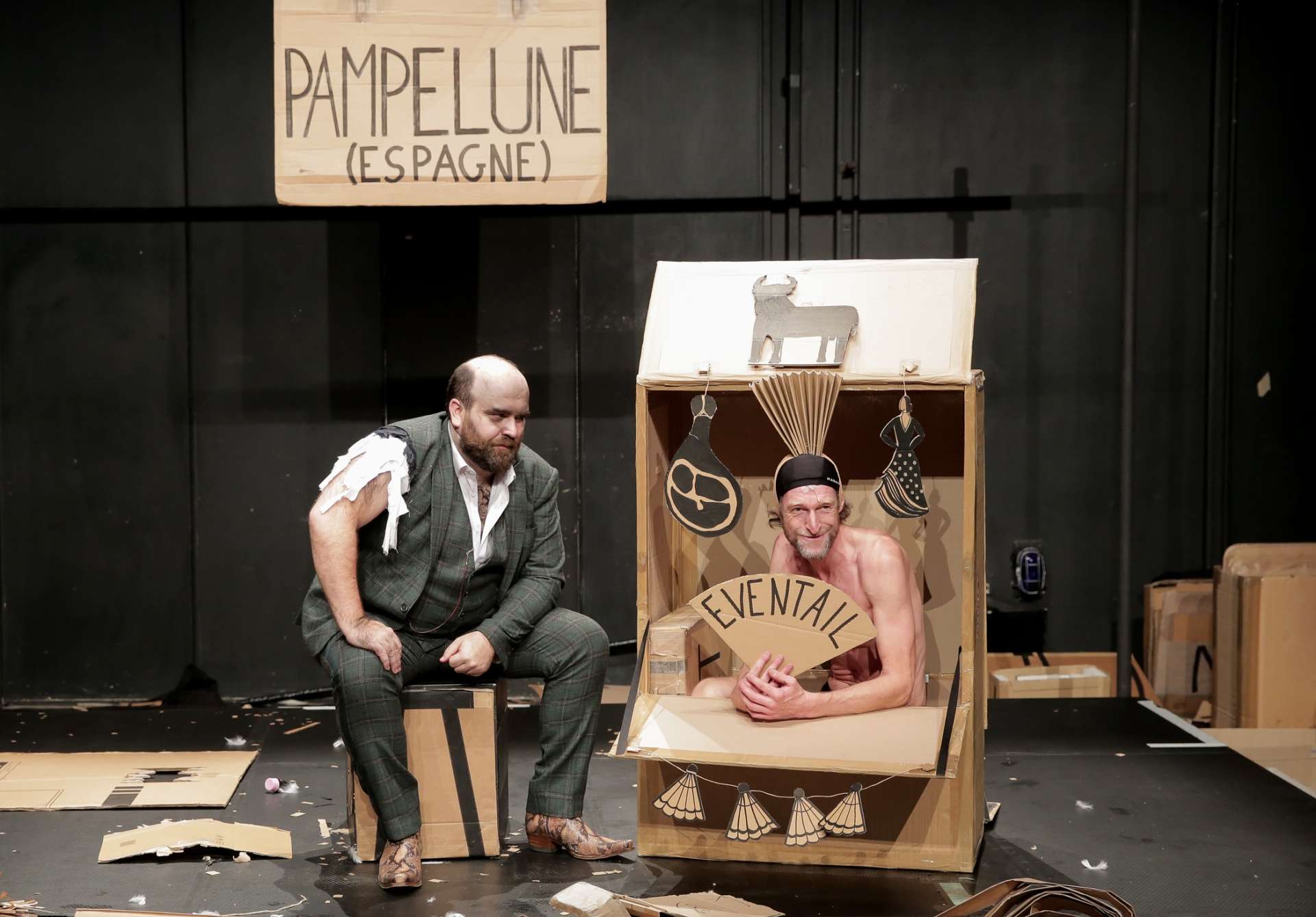 Deux personnages dans un décor en carton et jouent avec des éléments en carton