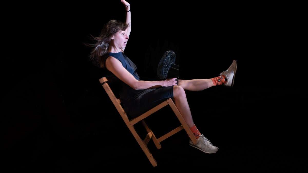 Femme en équilibre sur une chaise.