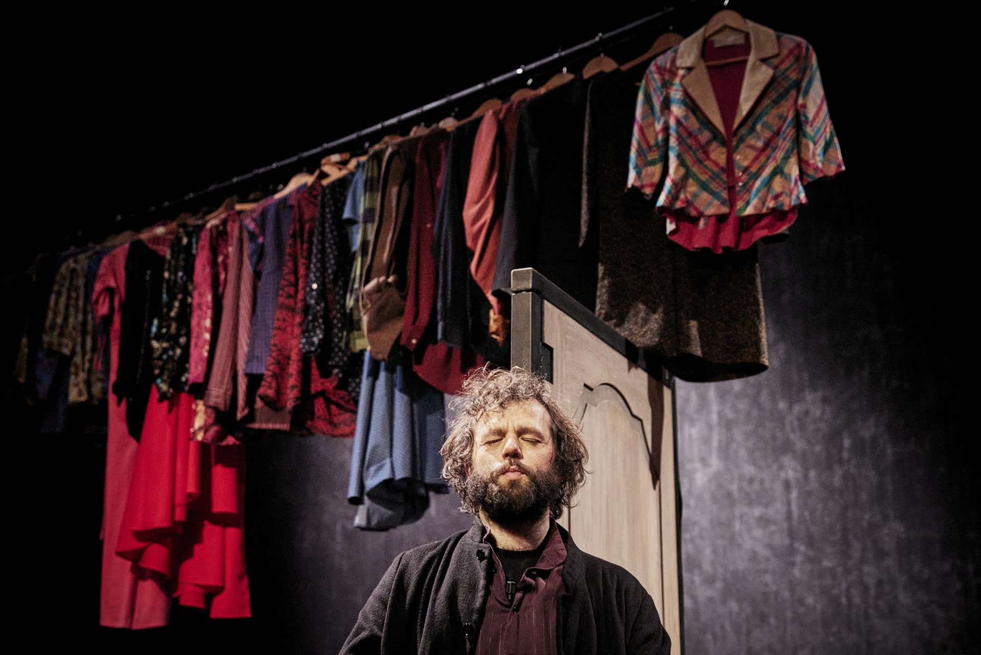 Personnage au premier plan les yeux fermés. Linge tendu en arrière plan.
