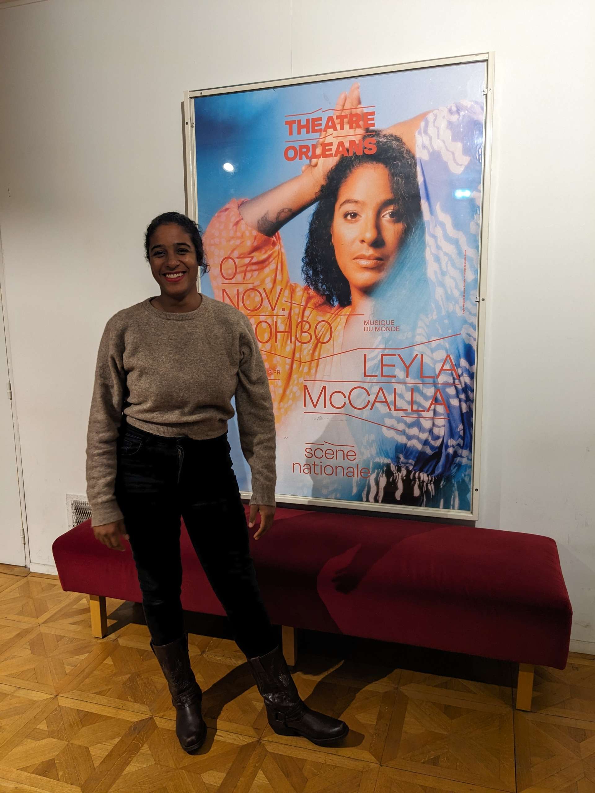 Leyla McCalla pose devant son affiche