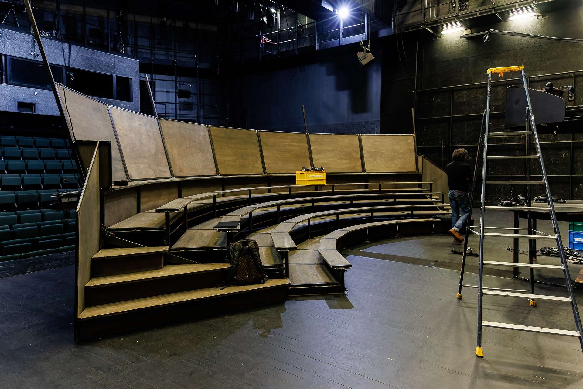 Gradin en bois monté sur le plateau, un technicien et un escabeau son à côté.
