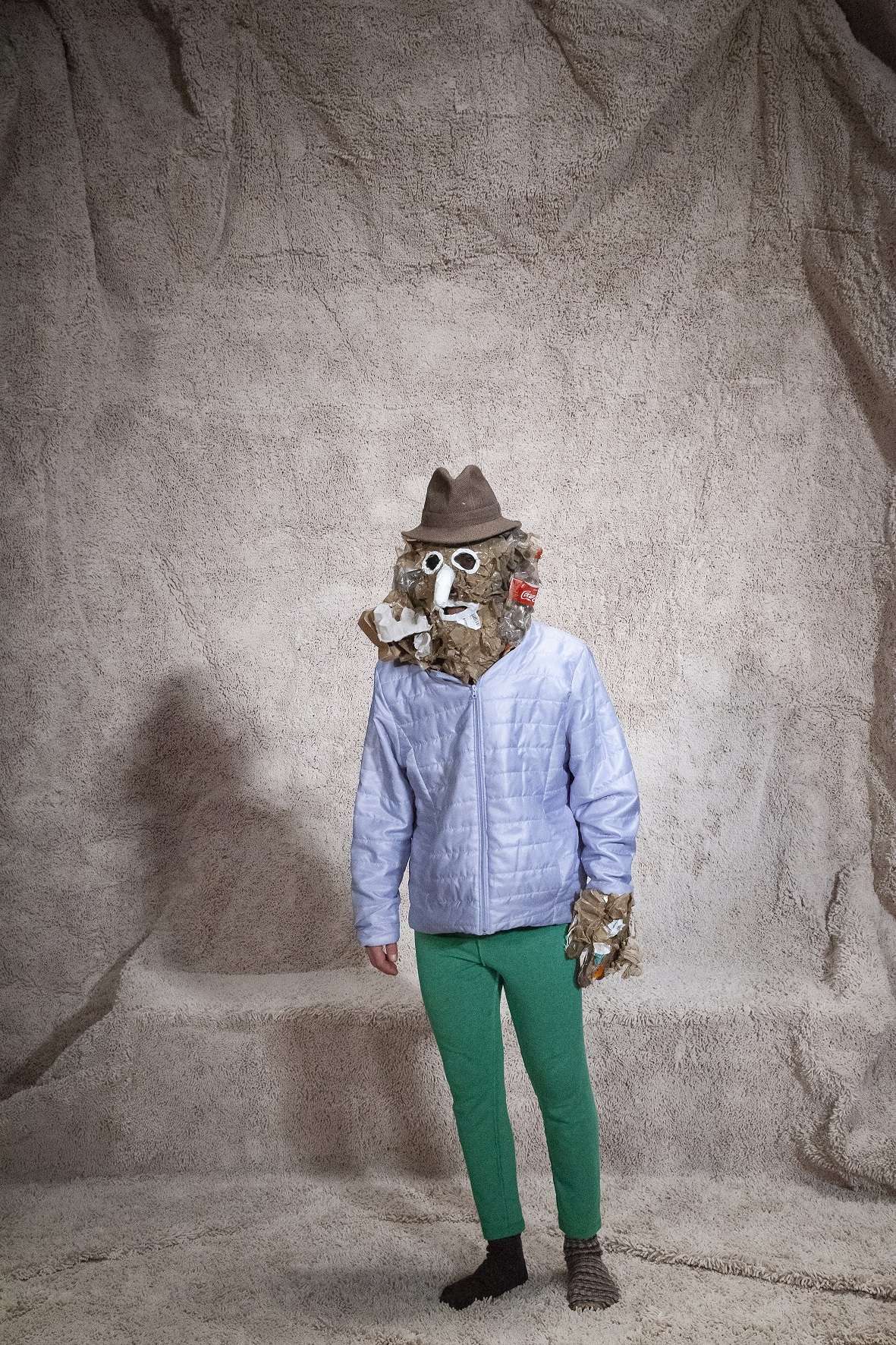 Portrait d'une personnage original avec un pantalon vert, une veste bleue, un chapeau et un masque.
