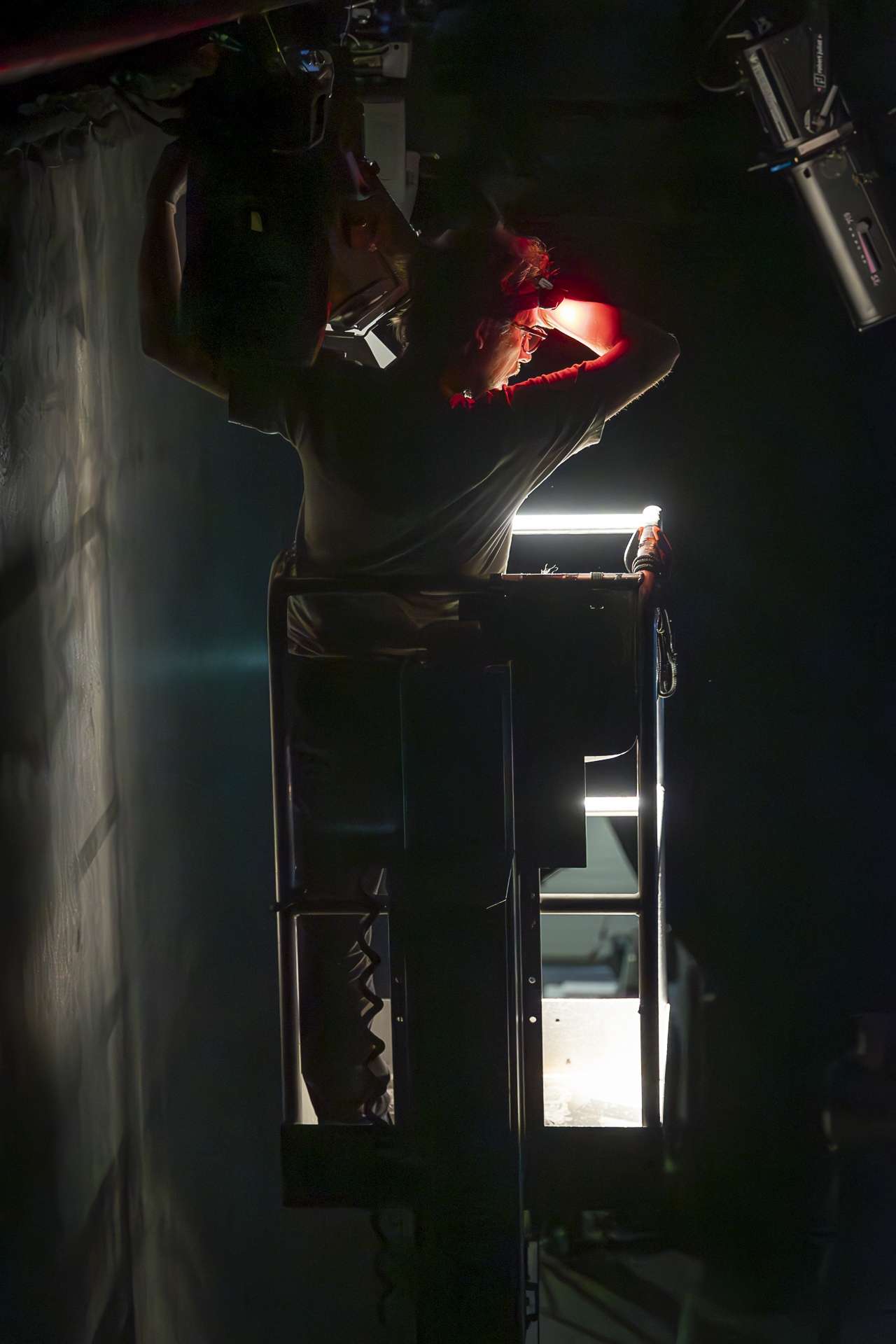 Technicien réglant l'ouverture d'un projecteur sur une nacelle.