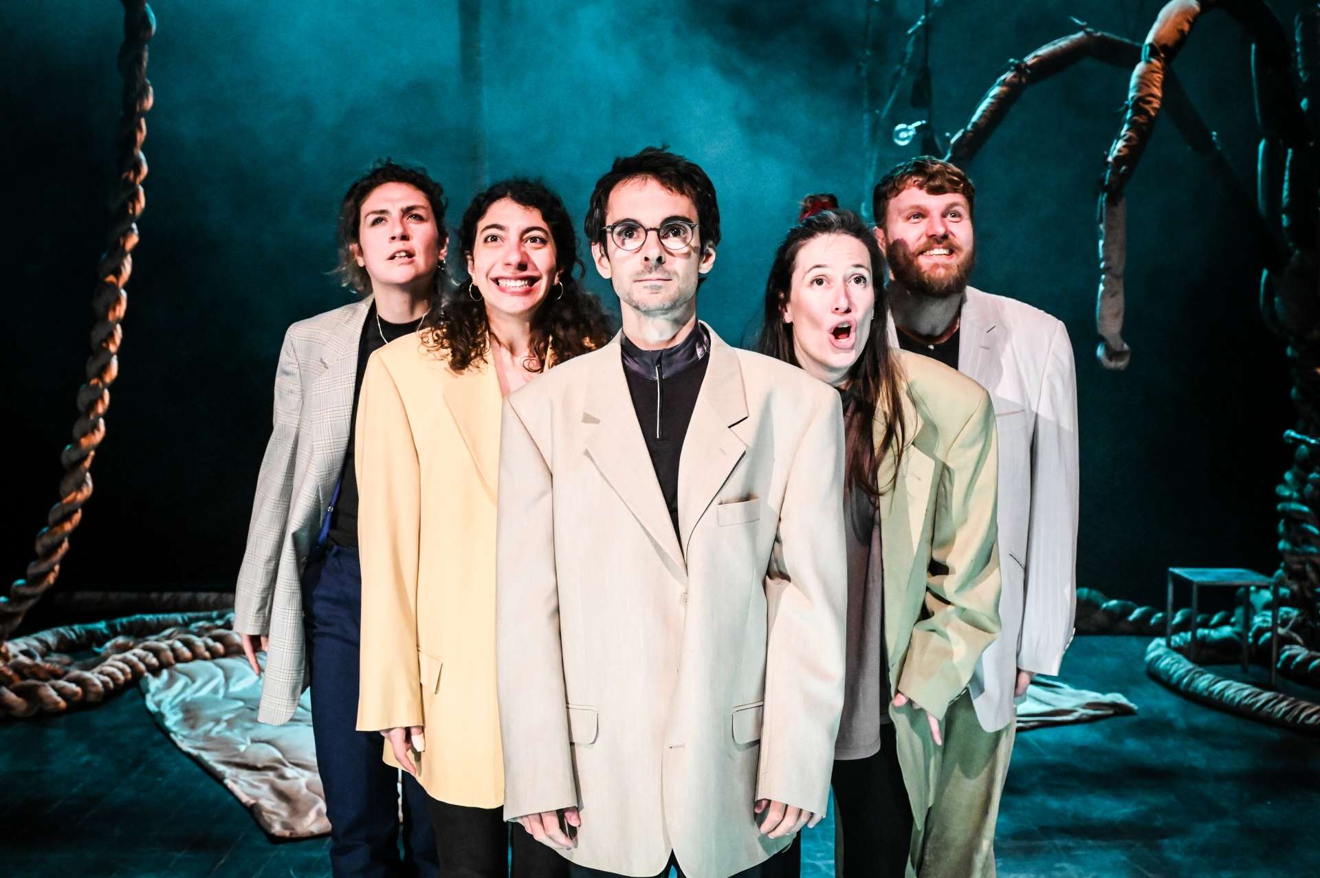 Groupe de cinq personnes face en costume et vestes beiges