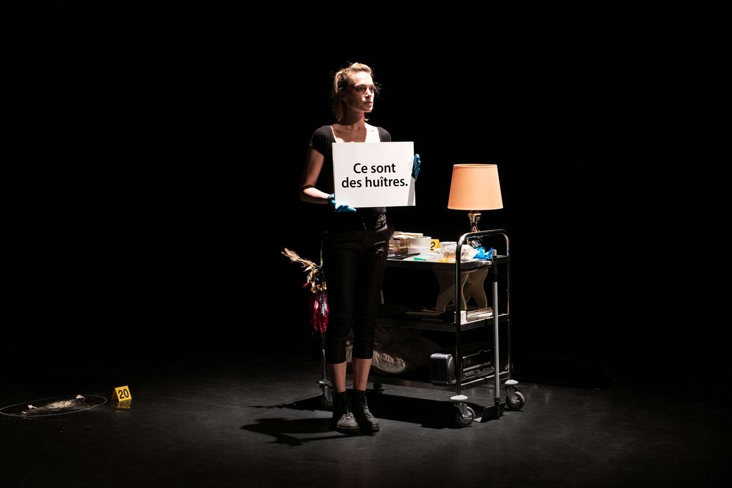 Femme debout dans le noir tiens une feuille devant elle