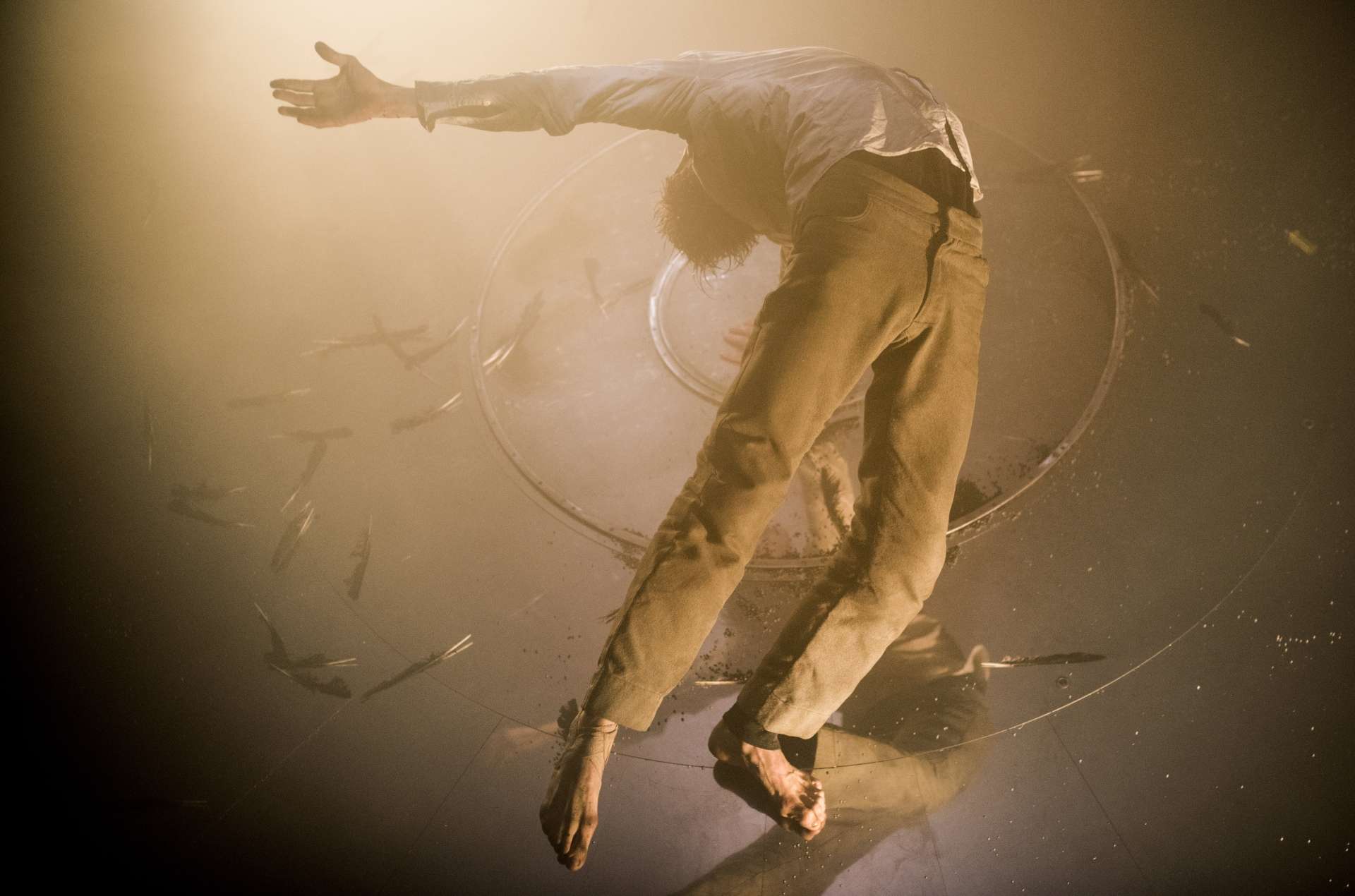 Un homme est un suspension dans les airs, la tête en arrière et les bras écartés.