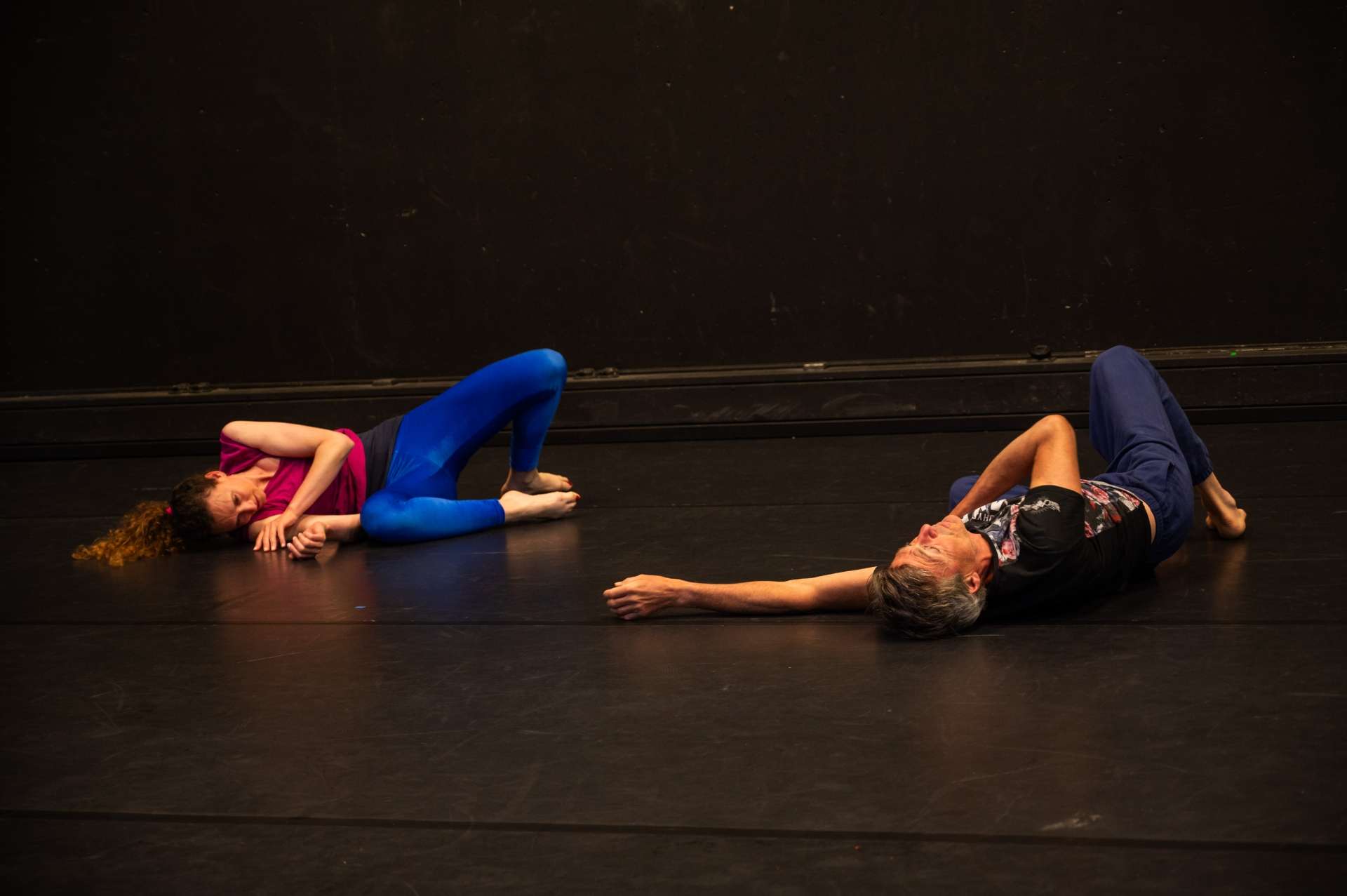 Photo de l'atelier de danse acrobatique, focus sur deux participantes, l'une sur le dos les jambes pliées. L'autre sur le côté, les bras contre elle.