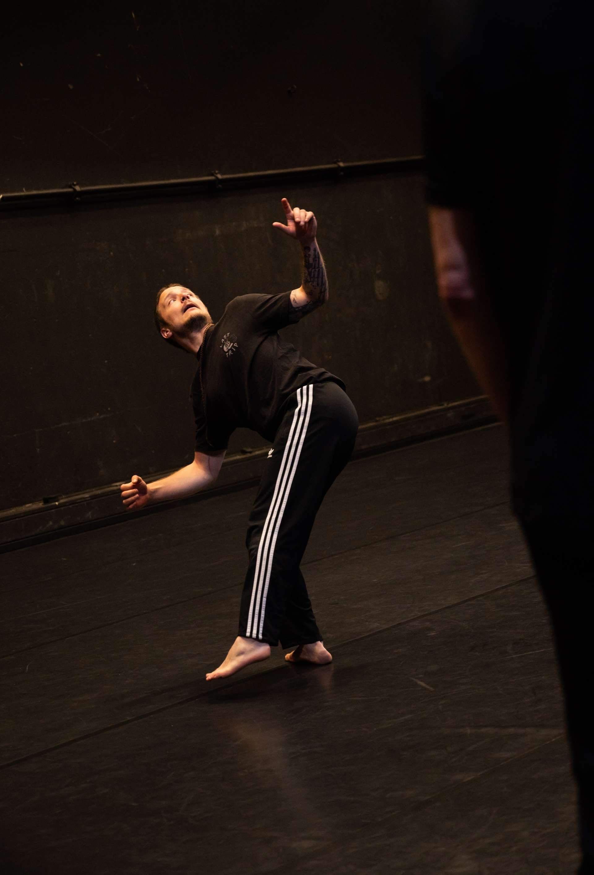 Photo de l'atelier de danse acrobatique, focus sur une participante prête à lancer son pied pour un saut en tournant.