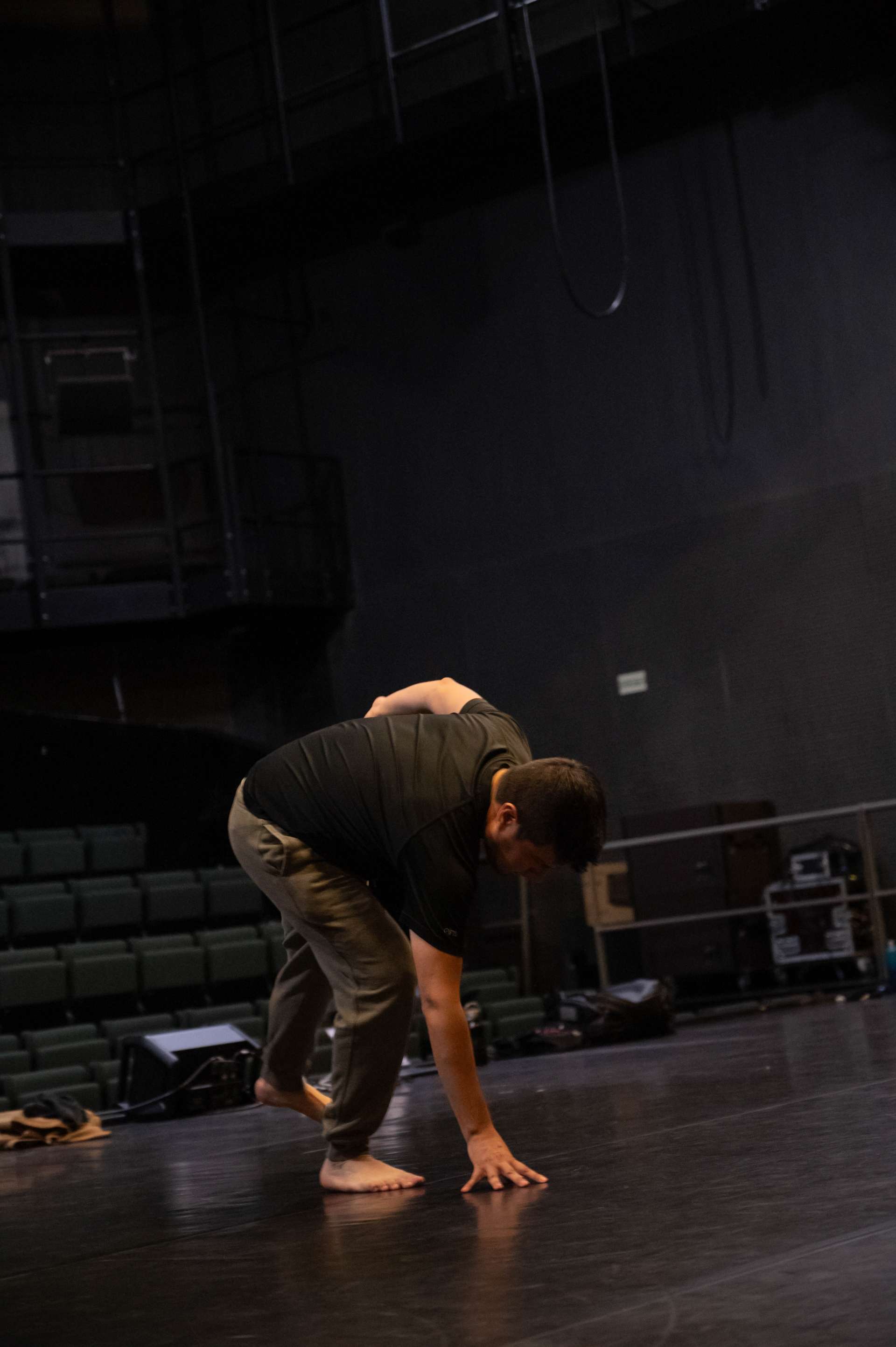 Photo de l'atelier de danse acrobatique, focus sur un participant accroupi, une main sur le sol.