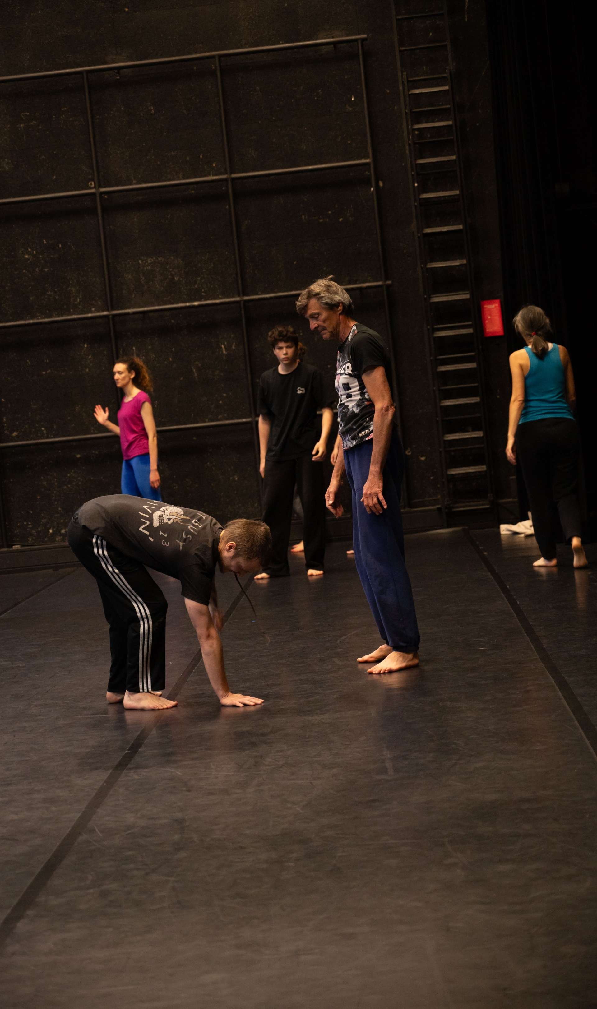 Photo de l'atelier de danse acrobatique, Clotaire montre les pas à un participant. Les autres un peu plus loin concentré·es sur les pas et les explications de Clotaire.