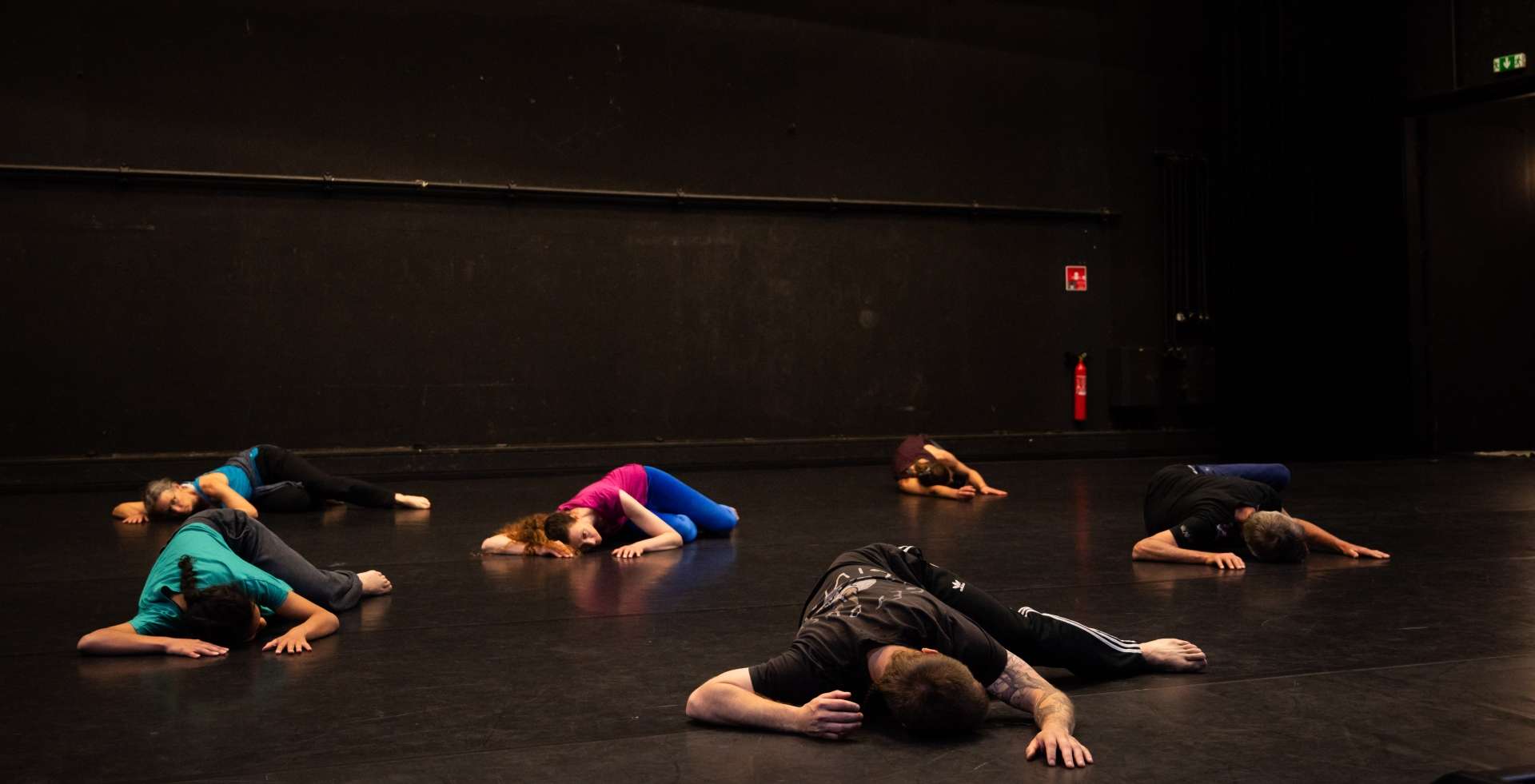 Photo de l'atelier de danse acrobatique, participants et participantes allongé·es au sol.
