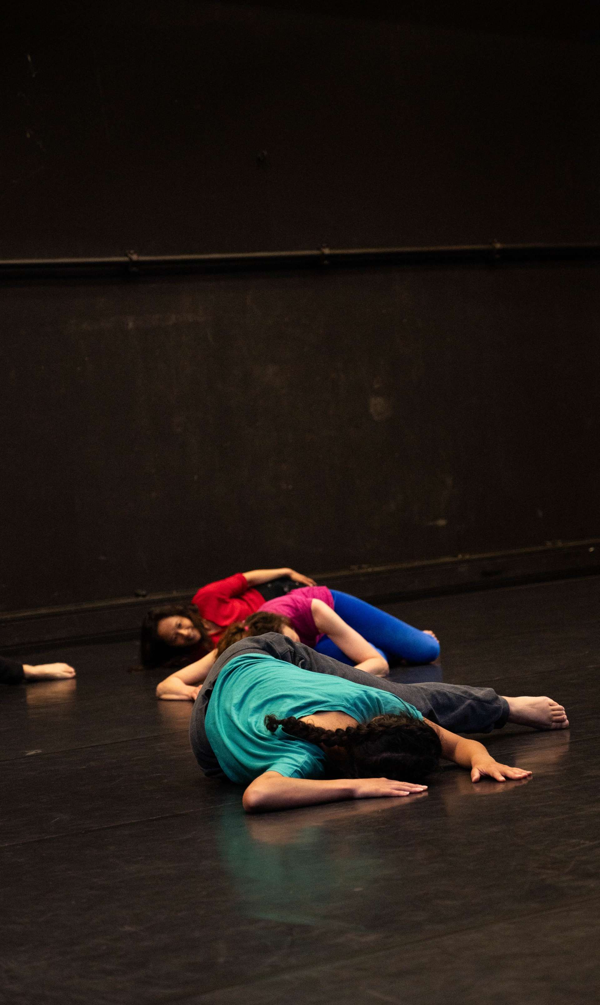 Photo de l'atelier de danse acrobatique, focus sur une participante allongée sur le sol.