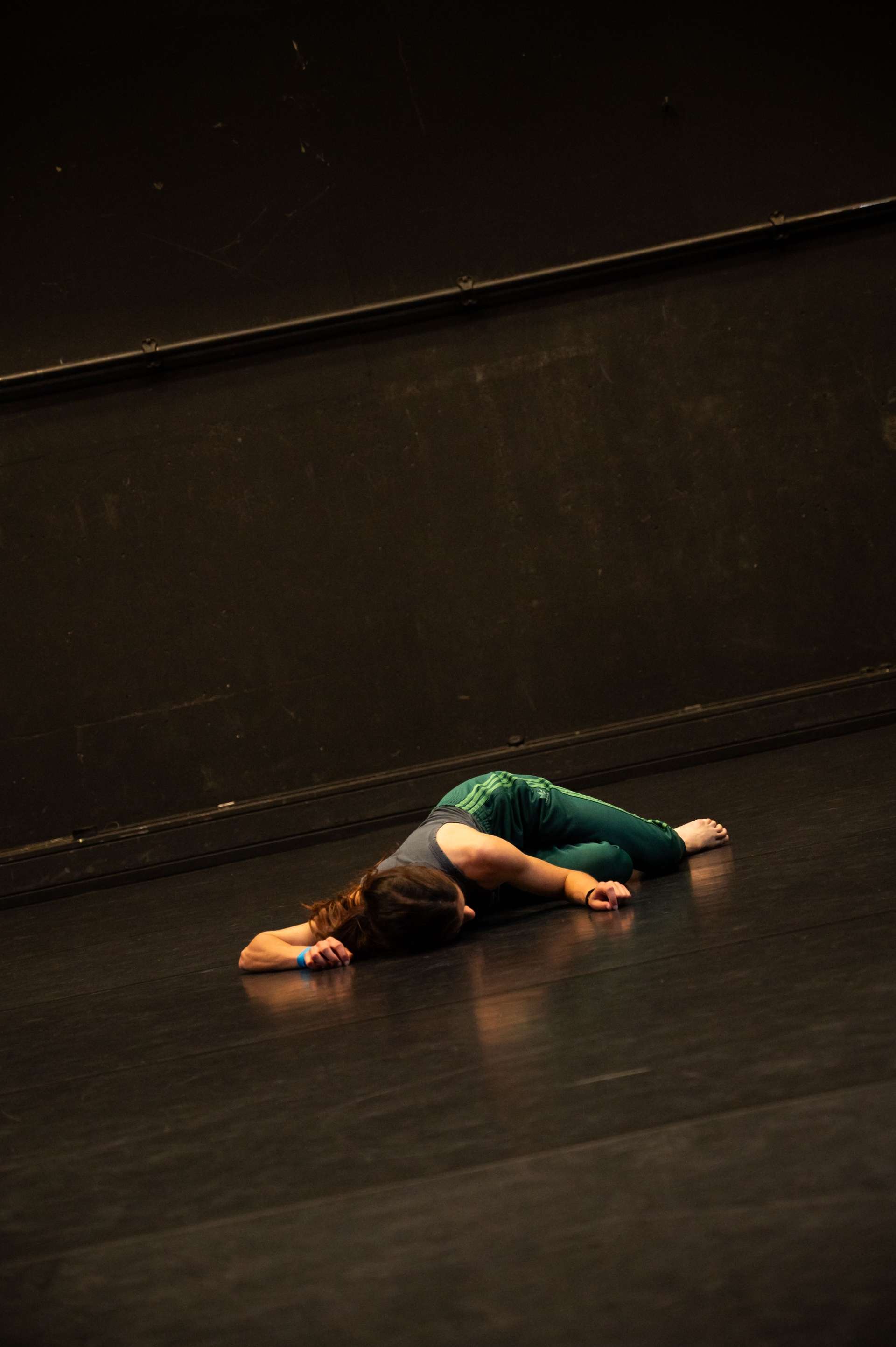 Photo de l'atelier de danse acrobatique, focus sur une participante allongée sur le sol.