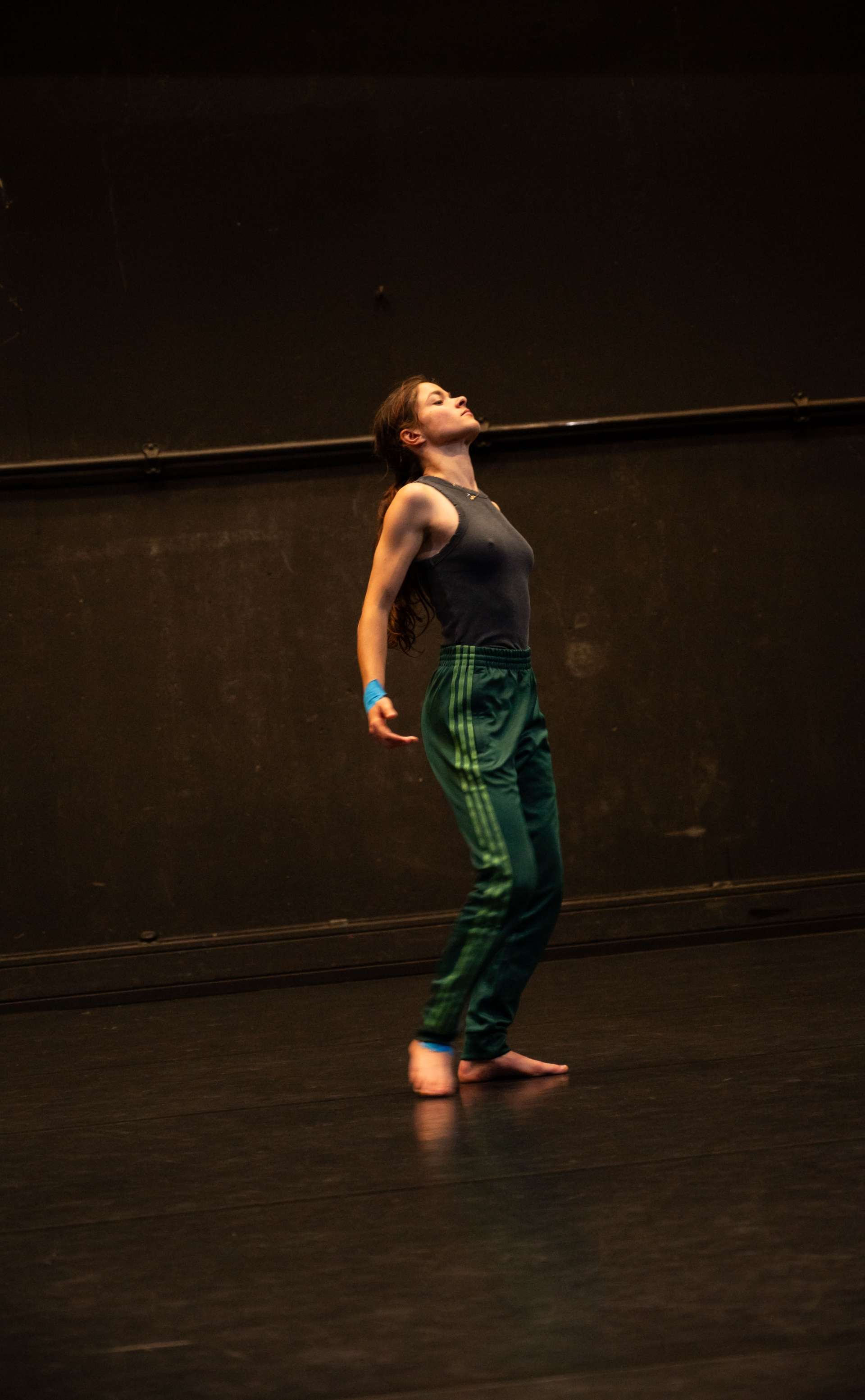 Photo de l'atelier de danse acrobatique, focus sur une participante debout le visage tourné vers le plafond.
