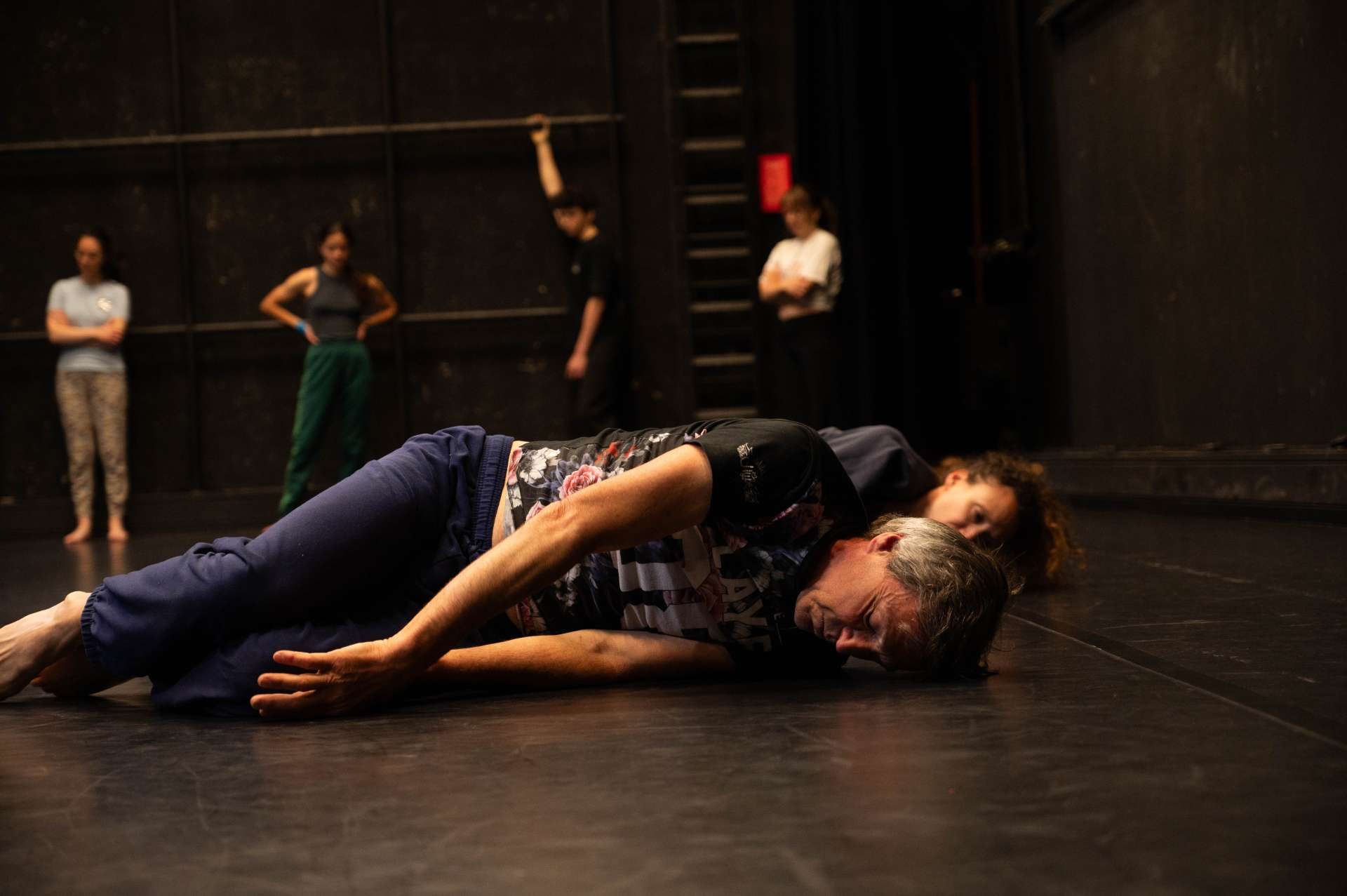 Photo de l'atelier de danse acrobatique, focus sur une participante allongée sur le sol.